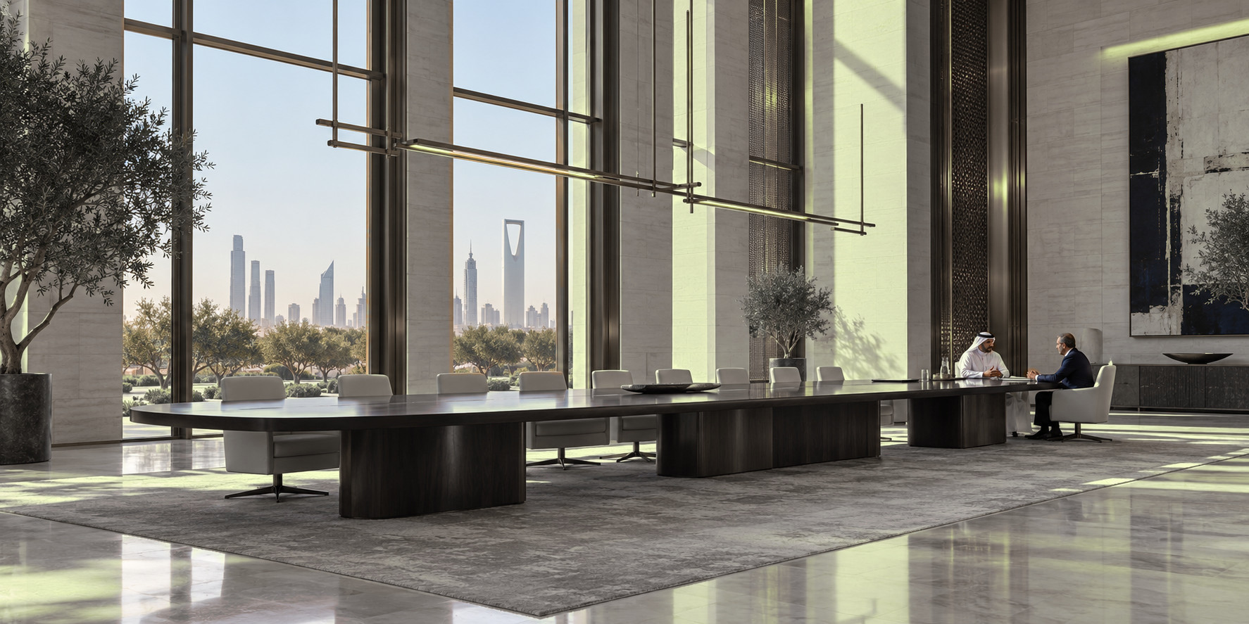 A long boardroom table in a Riyadh tower, two principals in conversation at its far end